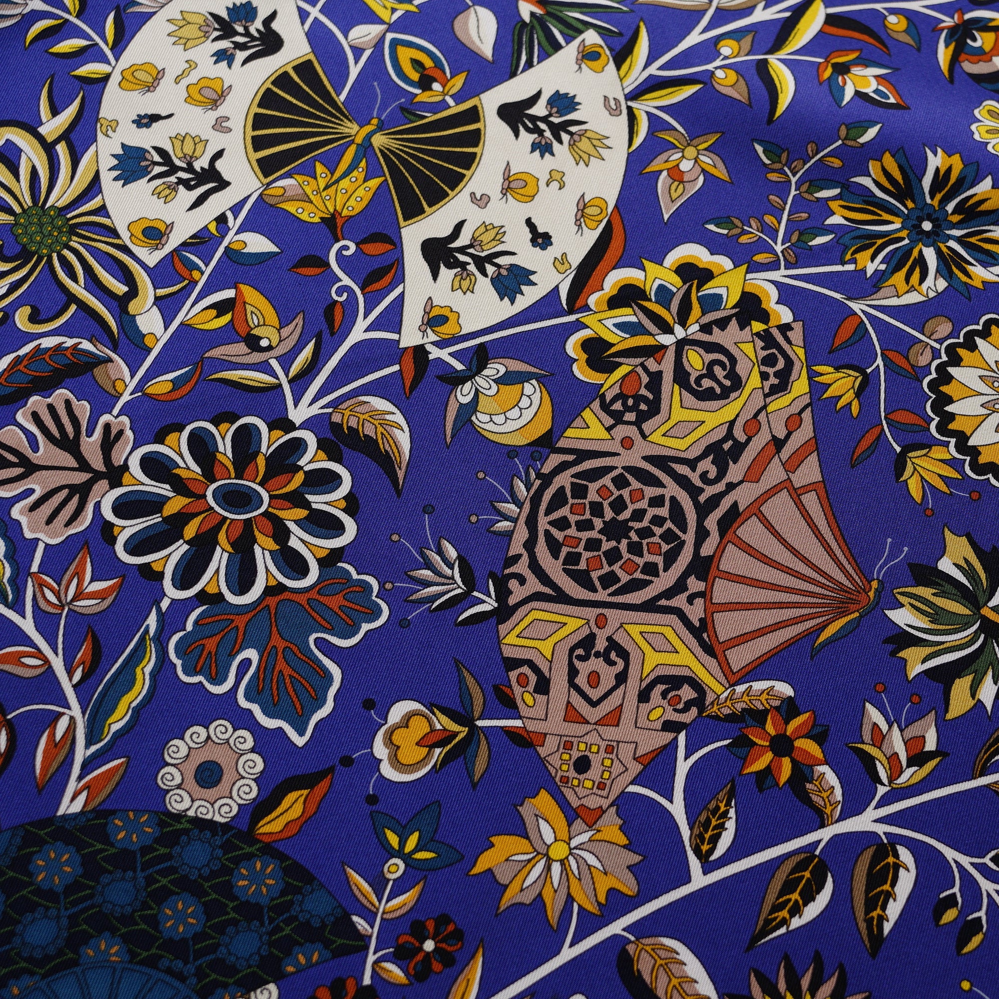 Détail de motifs floraux complexes et roulotté contrastant blanc sur carré Hermès Fleurs et papillons de tissus Christine Henry.