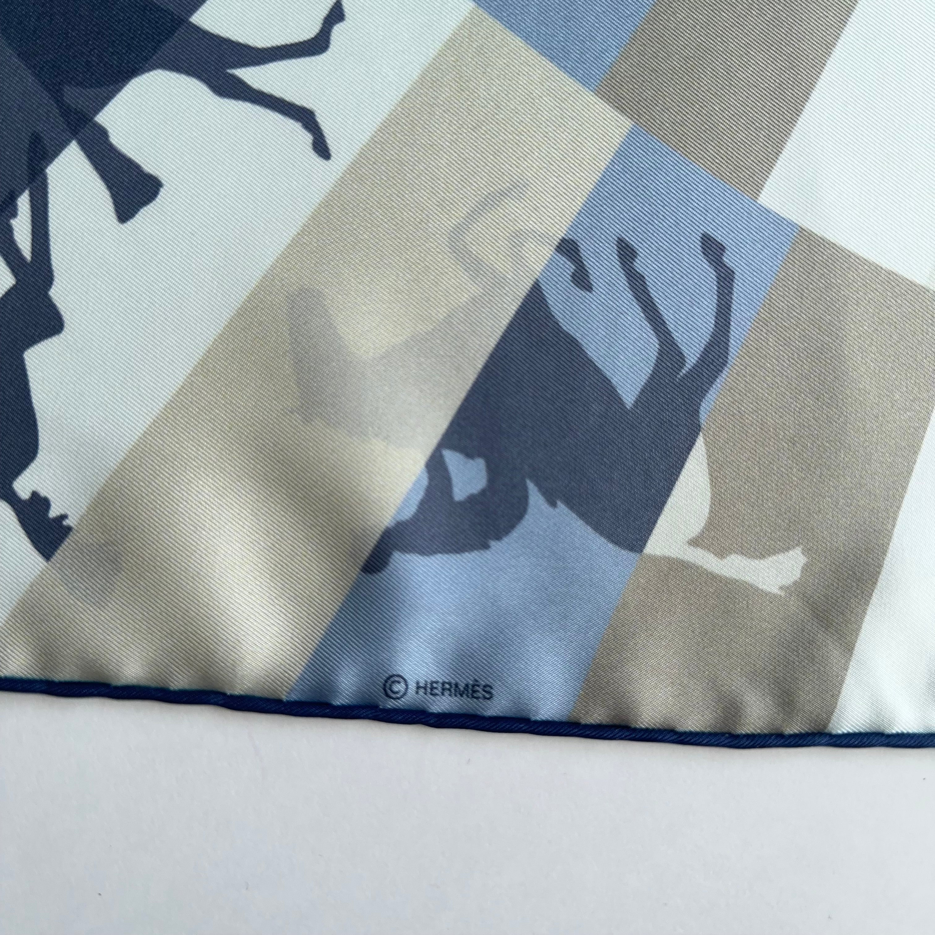 Détail du bord roulotté main bleu marine et mention du copyright "© HERMÈS" discrètement imprimée dans une bande grise.